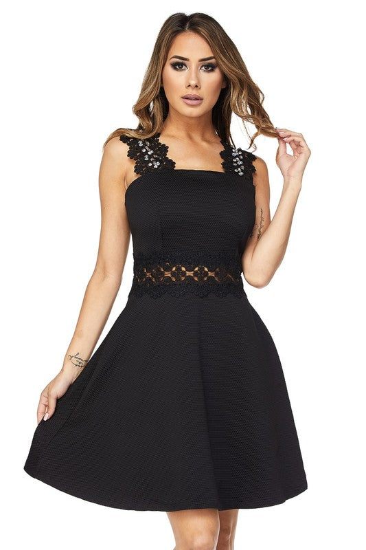 A short black dress with lace sleeves and waist pockets, featuring sequin accents on the front of the sleeves.