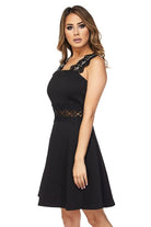 A short black dress with lace sleeves and waist pockets, featuring sequin accents on the front of the sleeves.