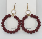 Wine-colored glass beaded circle drop earrings with gold-colored clasps.

Approximate Length: 2.25"