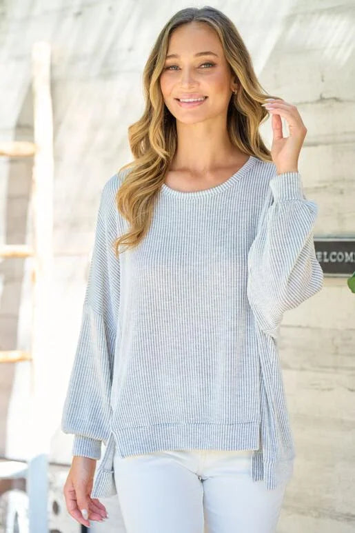 Grey Oversized Fit Long Sleeve Knit Top. Unique hemline with slit side and Bubble sleeves.
High and low silhouette.
