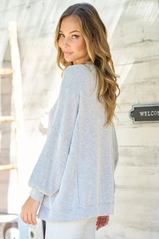 Grey Oversized Fit Long Sleeve Knit Top. Unique hemline with slit side and Bubble sleeves.
High and low silhouette.