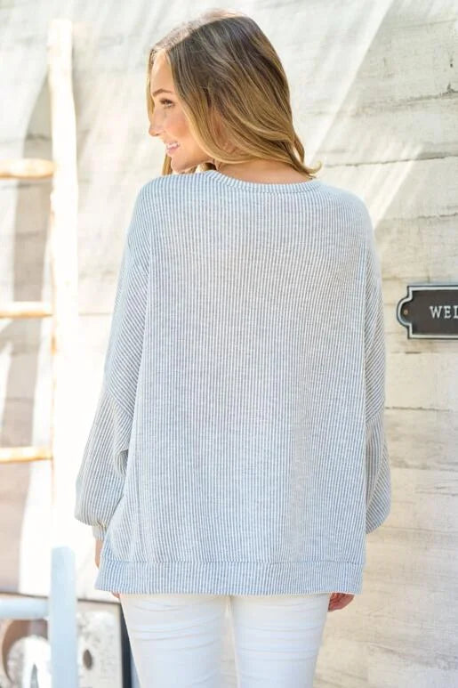 Grey Oversized Fit Long Sleeve Knit Top. Unique hemline with slit side and Bubble sleeves.
High and low silhouette.